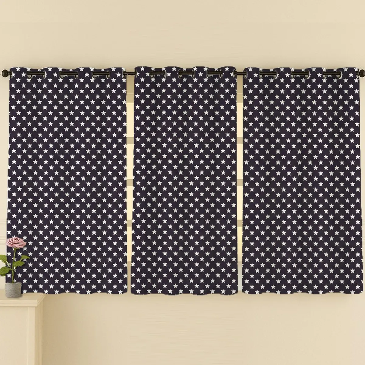 Three black and white patterned curtains hung across a wide window