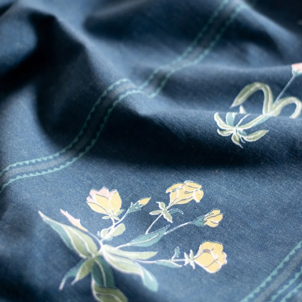 Close-up of blue curtain fabric showing floral motifs and border detailing