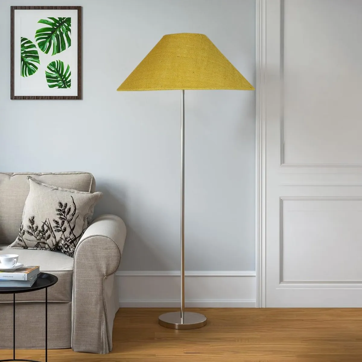 Yellow jute floor lamp with steel base styled beside a sofa in daylight