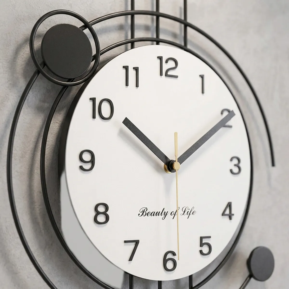 Close-up of the white round dial with black numerals on the metal wall clock