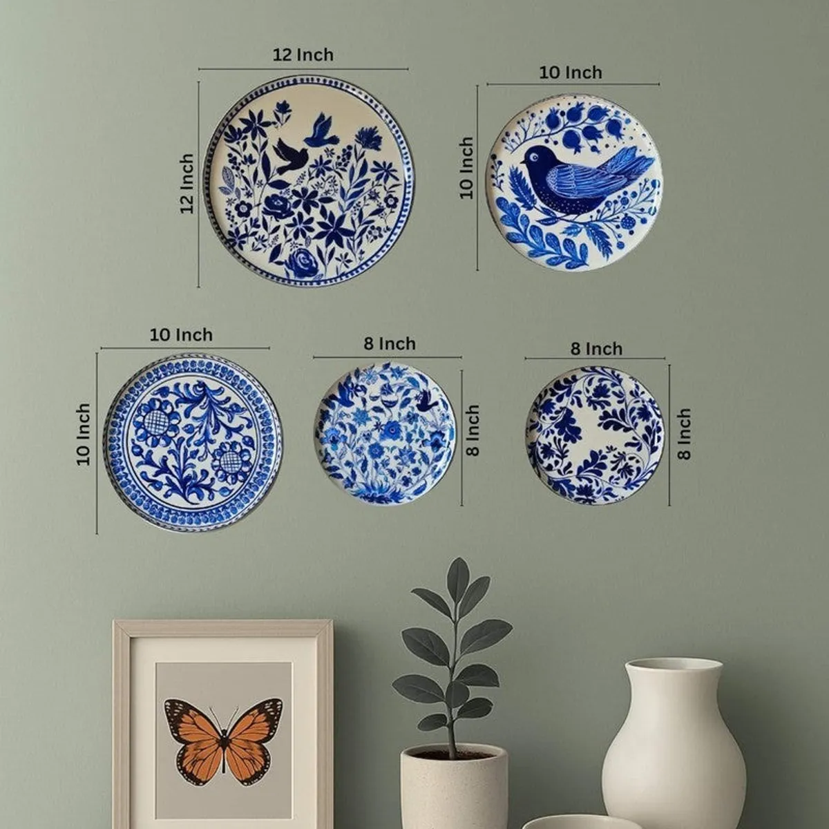 Five round blue-and-white wall plates shown together on a green wall