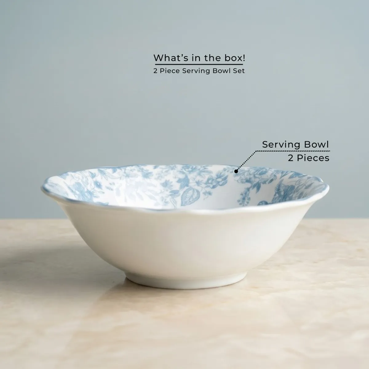 Blue and white floral serving bowl with scalloped rim on a marble surface