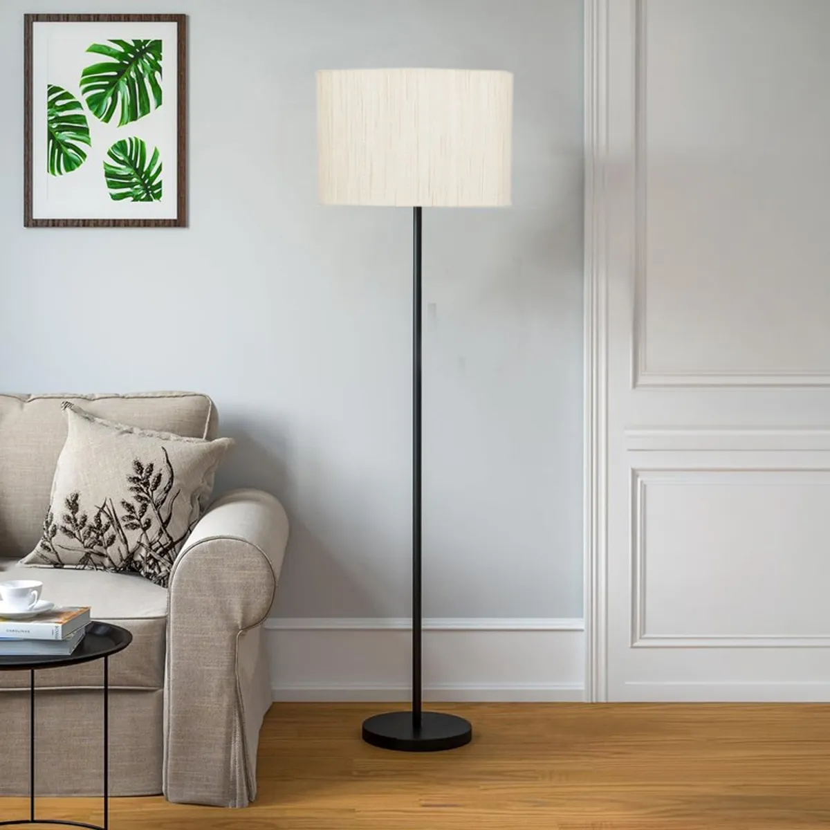 Ivory drum floor lamp in a bright living room beside a beige sofa