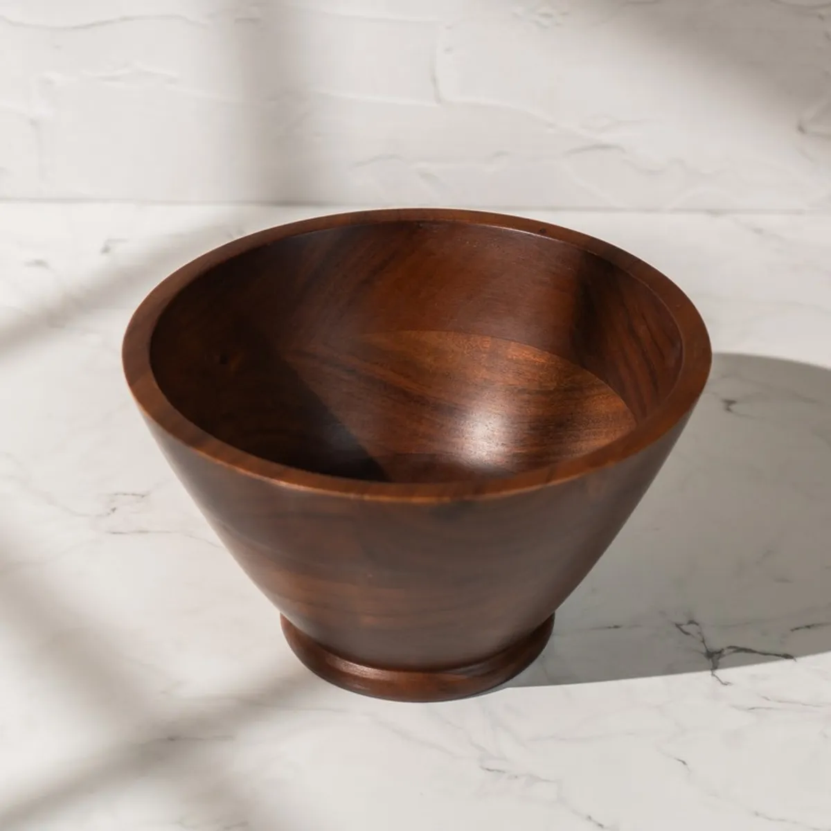 Empty brown wooden serving bowl showing its deep interior and raised base
