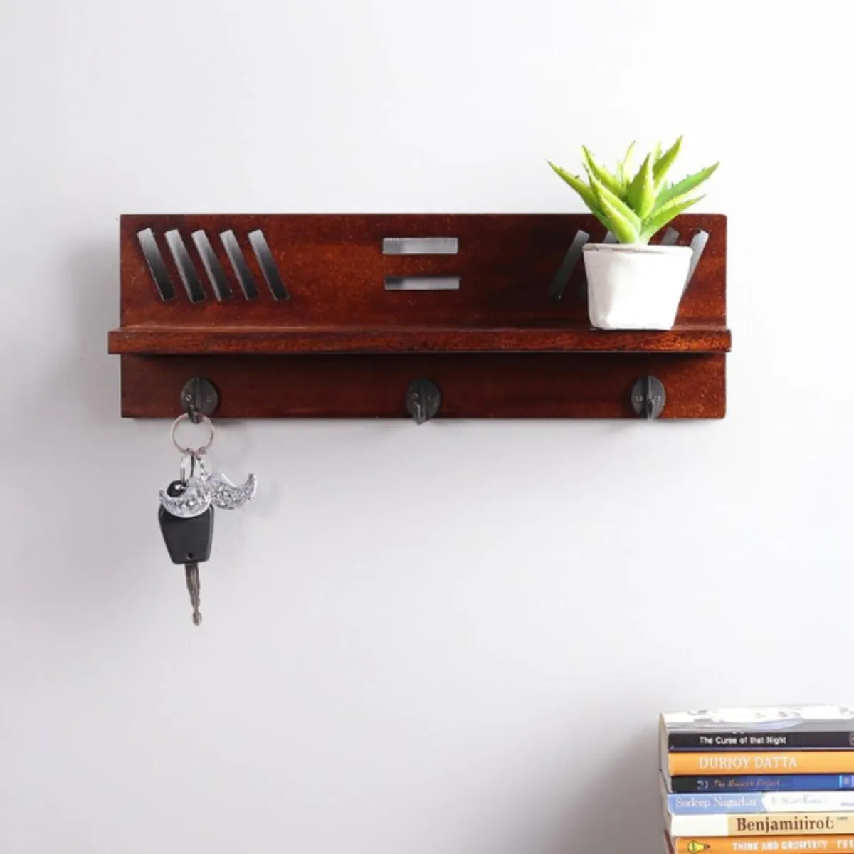 Front view of brown wooden key holder shelf with three hooks